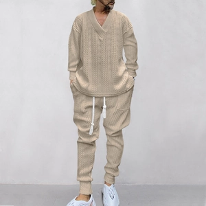 Detailansicht des beigen Jacquard-Strick-V-Ausschnitt-Pullovers und der Jogginghose