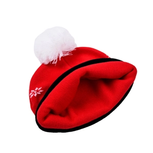 Rote und schwarze Weihnachtsstrickmütze mit großem weißem Pompon und Schneeflockenmuster