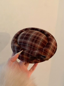 Close-up van Britse geruite baret met strikdetail in koffie- en beigetinten op wol