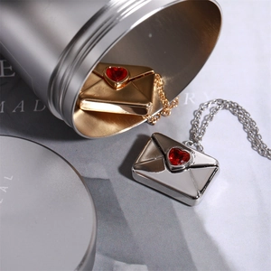 Detail of gold and silver envelope pendants with red heart stone on elegant chains