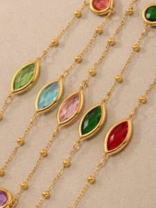Vue détaillée de pierres en verre colorées taille marquise sur chaînes perlées dorées