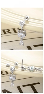 Detail of silver cat head earrings with drop zircon and threaded screw back design