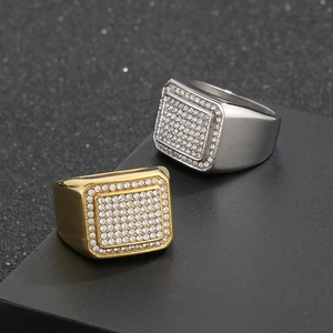 Dettaglio di anelli hip hop quadrati in oro e argento con cristalli incastonati