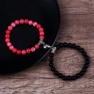 Detail of red and black stone beaded couple bracelets joined by heart magnetic clasp