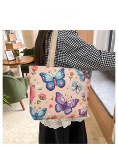 Detail of pink canvas tote bag with floral butterfly print and woven shoulder strap
