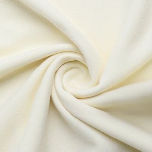 Vue macro d'un tissu en velours blanc crème aux détails de plis en spirale luxueux