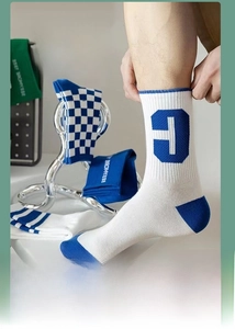 Close-up of athletic checkerboard and striped crew socks in blue and white knit cotton