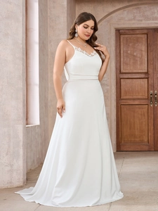 Close-up of white satin plus size wedding dress featuring delicate lace neckline and straps