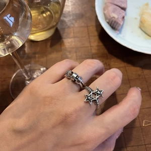 Dettaglio di anelli in argento vintage regolabili con stelle traforate e texture incisa