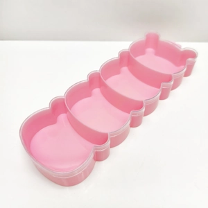 Detail of pink bear-shaped storage box with four compartments and transparent lid