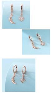 Macro detail of asymmetric rose gold moon and star earrings with cubic zirconia stone