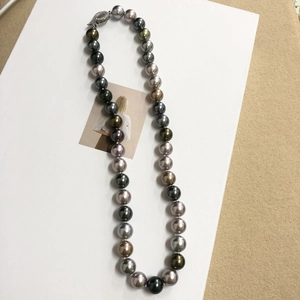 Close-up of multicolored Tahiti style pearl necklace with metallic fish hook clasp