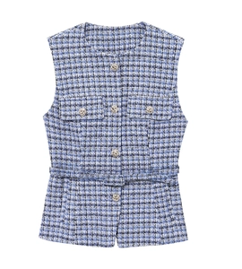 Detail of tweed texture and metallic buttons on a V-neck vest with matching belt