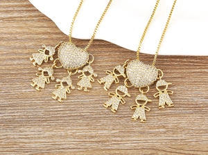 Dettaglio di ciondoli a cuore placcati oro 18k con figure di bambini e pietre di zircone