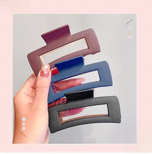 Macro detail of large matte hair claws in dark red, navy blue, and black resin material