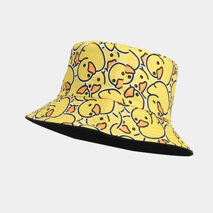 Close-up of vibrant yellow bucket hat featuring a dense cartoon duck pattern and black lining