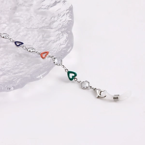 Detail of colorful enamel hearts and faceted beads on a silver-tone multi-use glasses chain