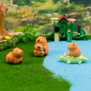 Miniature Capybara resin figurines on green grass near a pool for desk decoration