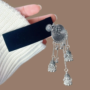 Gros plan de boucles d'oreilles ethniques en argent vintage avec glands et clochettes