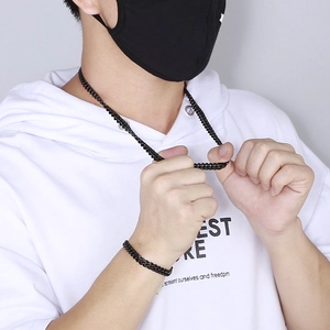 Gros plan sur l'ensemble collier et bracelet à mailles cubaines noires sur un sweat