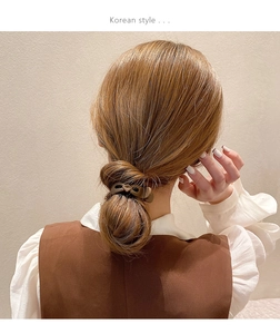 Detail view of a matte brown shark clip securing a high ponytail in Korean style hairstyle
