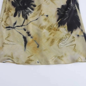 Detail of elegant satin dress with yellow watercolor wash and black floral ink print