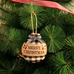 Détail d'un ornement de Noël en toile de jute ronde avec texte Merry Christmas sur un sapin