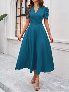 Detail of blue V-neck midi dress with puff sleeves and textured fabric on model