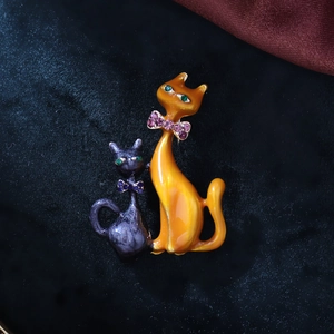 Detail of cute cat brooch with enamel finish and sparkling rhinestone bow accents