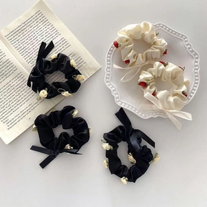 French style floral scrunchies with 3D roses and elegant bow ribbons on a vintage plate