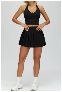 Detail of black halter yoga crop top and pleated sports skirt set with breathable fabric