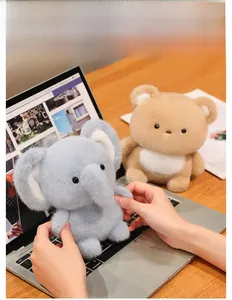 Close-up of soft plush elephant and bear dolls as cute desk companions on a wooden table