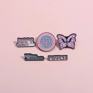 Detailed view of psychology enamel pins featuring butterfly and professional slogans