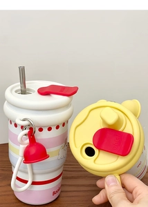 Detail of multi-color striped thermal mug featuring a dual-drink lid and cute cartoon dog