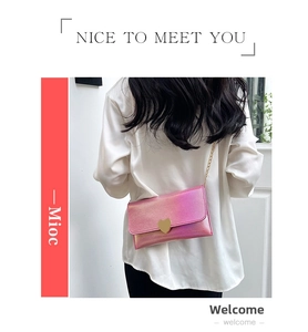 Detailed close-up of a pink gradient mini bag with golden heart clasp and chain strap