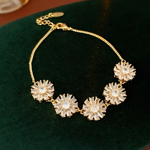 Close-up of gold plated floral bracelet with cubic zirconia petals on velvet background