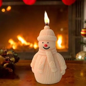 Christmas snowman scented candle with knitted texture and snowflake scarf on wooden table