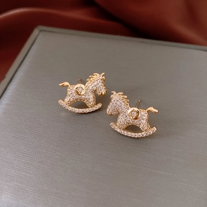Macro detail of golden rocking horse stud earrings with sparkling pave-set cubic zirconia