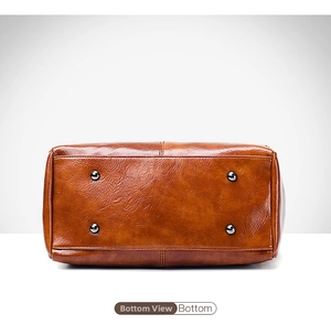 Detailed bottom view of brown oil wax leather bag with silver metal protective studs