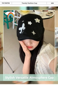 Detail of black newsboy cap with silver stars and a white faux fur bow decoration