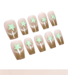 Detail of coffee to nude gradient press-on nails with cat-eye effect and green star motifs