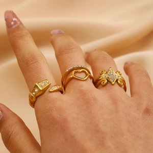 Detailopname van 18K vergulde open ringen met hartuitsparing en slangenpatroon details