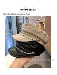 Detail of quilted faux leather baker boy caps with pearl chains and metal links
