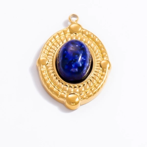 Close-up of vintage oval gold pendant with dark blue stone and embossed metal texture