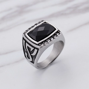 Macro detail of men's silver ring featuring a square black gemstone and side diamonds