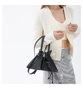 Detail view of gothic black PU leather handbag with decorative silver cross charm and tassel