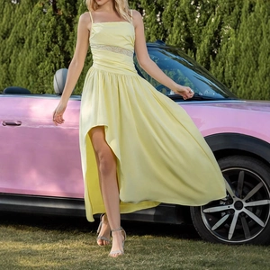 Detail of yellow sleeveless dress with sheer lace waist panel and flowing ruffled hem