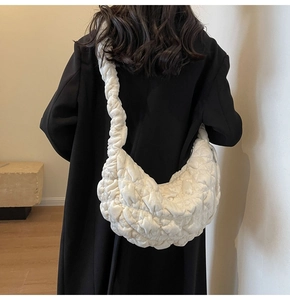 White quilted crescent shoulder bag with pleated velvet texture on female model back