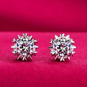 Detailed close-up of snowflake-shaped silver earrings with sparkling cubic zirconia stones