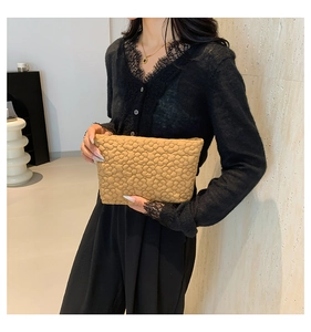Detailed close-up of khaki floral textured clutch with soft quilted embroidery pattern